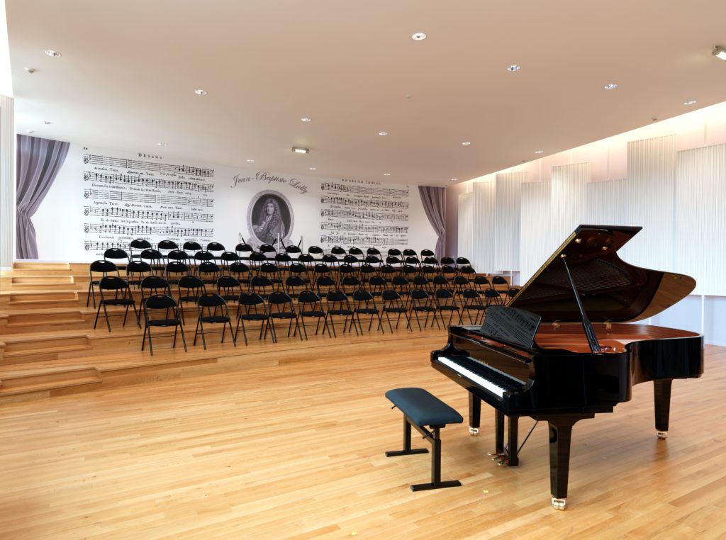 Photo d'un mur imprimé avec un visuel de notes de musique dans une salle de piano dans un conservatoire de musique