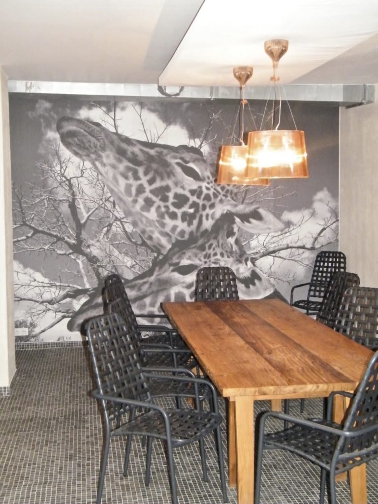 photo d'une toile imprimée en noir et blanc avec des têtes de girafe dans une salle à manger