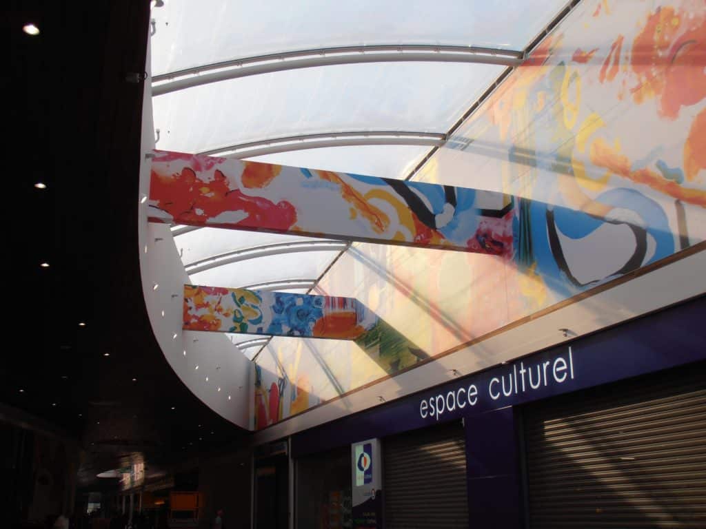 Photo d'un mur et poutres imprimé devant l'espace culturel de la galerie commerciale d'un centre E. Leclerc