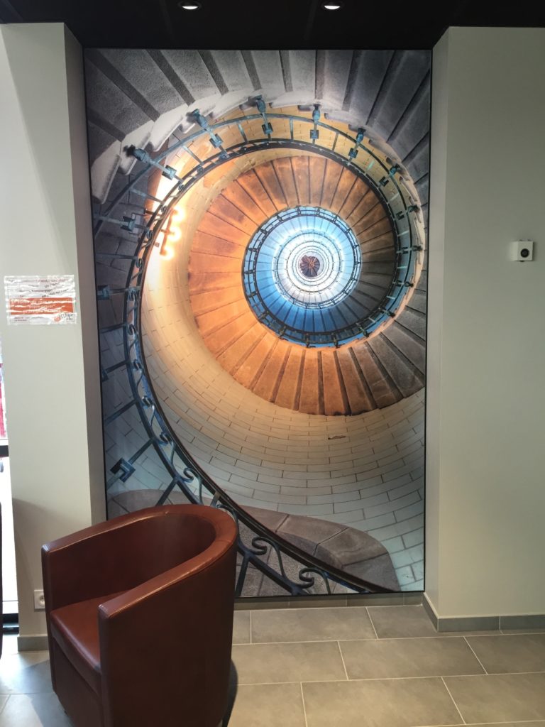 Photo d'un mur imprimé avec un visuel d'escalier en colimaçon