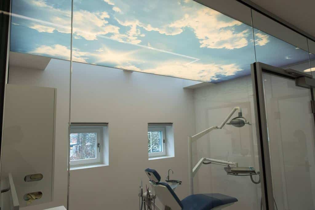 photo dun plafond avec une toile translucide imprimé avec un ciel nuageux au plafond d'un cabinet de dentiste