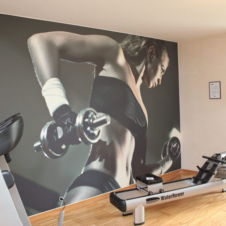 photo d'un mur imprimé avec une un corps de femme portant des haltères