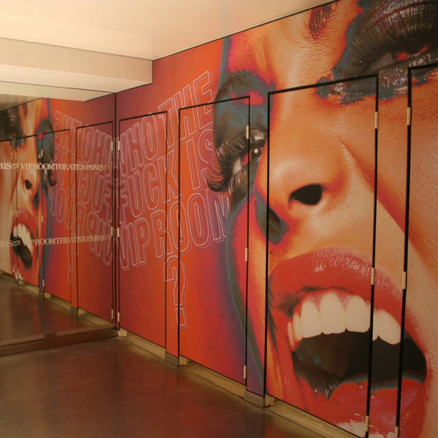 Photo des sanitaires du VIP room avec des murs et portes imprimés avec un visuel de femme